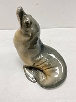 Front and side view of the vintage porcelain seal sculpture with glossy gray and brown glaze, showing detailed features and shape.