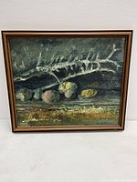 Frontal view of the oil painting showing the fish skeleton and stone motif in dark tones, signed at the bottom right corner.