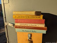 Stacked view of all six hardcover books showing titles on spines including Pilgrim's Progress, A Journey to the Center of the Earth, Short Stories by Oscar Wilde, Utopia, The Effayes, and The Poems of Shelley.