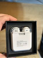 Back view of one wireless ear bud charging case showing printed specifications and compliance logos.