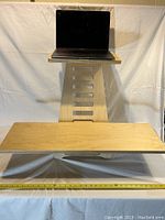 Standing desk fully assembled with laptop on top, showing ergonomic adjustable design and natural wood finish.