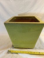 Front view of green glazed terracotta square planter with measuring tape showing approximately 10 inches width.