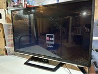 Front view of LG 47 inch LED TV switched on to LG startup screen with stand visible
