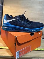 Nike Air Max 2015 men's shoe resting on original orange Nike box with size label visible.
