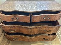 Front angled view of the dresser with four drawers open showing wood grain and missing bottom pane in one drawer