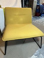 Yellow lounge chair displayed from the front showing upholstery and leg style.