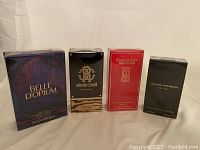 Four boxed fragrances in original packaging arranged side by side