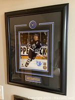 Full view of framed signed photo and nameplate.