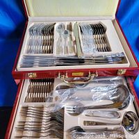 Upper tray showing wrapped dinner forks, dinner spoons, teaspoons and dinner knives in molded foam
