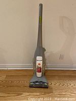 Front view of the Hoover Floormate Deluxe upright floor cleaner in grey and white with transparent tanks.
