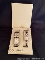 Boxed set showing two Kenneth Cole watches, men's and ladies', inside the original white packaging with logo.
