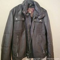 Front view of Marlboro Classics men's black leather jacket showing two chest flap pockets with snap buttons, two zippered side pockets, and snap-button collar.