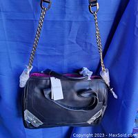 Full view of new black leather Botkier purse with chain strap and pink lining, showing original tags and gold-tone hardware corner protectors.