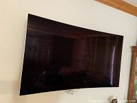 Front view of curved Samsung television mounted on wall