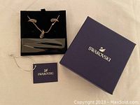 Swarovski box with necklace and earrings displayed, including brand tag visible