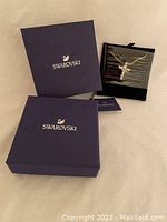 Original Swarovski packaging with navy blue boxes showing brand name and logo, and necklace displayed inside