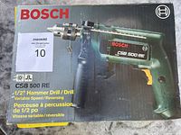 Photo of original box with Bosch branding and model info on lid showing 1/2" hammer drill with variable speed and reversing.