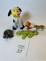 Photo of five ceramic animal figurines on a white background showing a dog, turtle, lizard, bird, and tiger.
