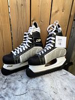 Pair of black and white ice skates with DR logos and silver blades, in good visible condition.