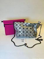 Silver geometric shape-shifting purse and hot pink PVC bag shown side by side.