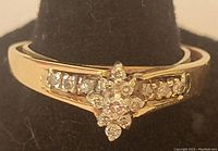 Front view of ring showing diamond cluster and side stones