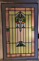 Full view of the stained glass window panel showing overall design and condition under ambient indoor lighting.