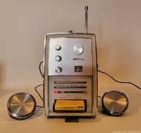 Front view of Kuberoal solid state 8 track AM/FM radio with two round silver-tone external speakers connected, RCA 8 track tape inserted in player slot, antenna extended.