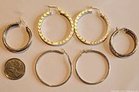 Overview of all three pairs of sterling silver hoop earrings next to a Canadianquarter for size reference.