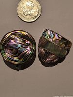Overview of two abalone shell and silver/alpaca pill boxes next to coin for scale.