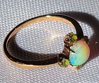Ring angled view showing opal center and peridot accents