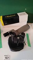 Bushnell Spacemaster II telescope with original box and Nikon binoculars with carrying case placed on a flat surface.