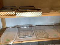 Shelf with multiple glass plates including floral and geometric designs.