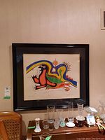 Overall view of framed print hanging on wall above furniture