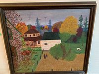 Full front view of framed landscape painting showing two houses, trees, people and animal in a scene with autumn colors.