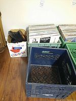 Overview of two plastic crates, one filled with vinyl records and one empty