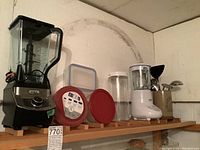 Wide view of shelf with Ninja blender, food storage containers with lids, Cuisinart blender, and cooking utensils holder.