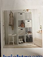 Close-up photo of assembled shelf used for storage showing cubes with baskets, shoes, and bag