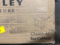 Cardboard box showing Crosley CF4403-AC bar cabinet branding and box damage
