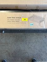 Photo of the boxed twin daybed showing the label 'Daybed / Diván / Lit de jour', espresso color, weight 51.70 lbs (23.50 kg).