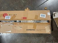 Close-up of the cardboard box showing the brand WLIVE and item description 'Fabric 3 Drawer Storage Cabinet / HH' with box partially damaged but sealed.
