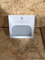 Front view of the sealed Google Charging Speaker Dock box, showing product image and model info