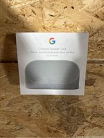 Front view of the Google Charging Speaker Dock box showing the product image and logo.