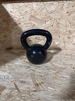 Front view of the black cast iron kettlebell showing its shape and handle.