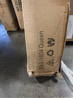 Side view of cardboard box packaging with product code T40-1604 and label 'Queen' indicating queen size bed frame inside.