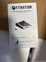 Instruction manual showing brand 'Fitnation' and usage instructions, advising to not use in standing position.