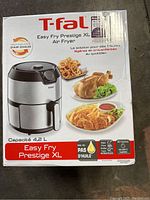 Front view of the sealed T-fal Easy Fry Prestige XL 4.2L air fryer box showing product image and food serving suggestions.