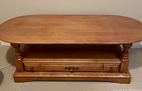 Full view of oval wooden coffee table showing top surface and legs