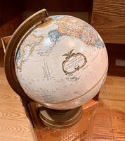 Photo showing the North American and Pacific Ocean side of the globe, highlighting the brass-toned meridian and base.