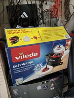 Box of Vileda EasyWring spin mop and bucket set showing product image and details.
