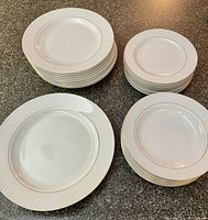 Stacked sets of dinner plates, small plates, side plates, and soup bowls showing the full collection with gold trim.
